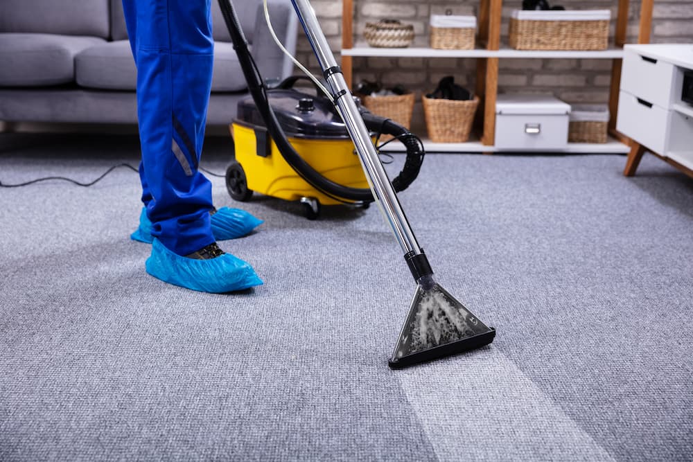 mid shot of a person using a carpet cleaning machine on dirty carpet